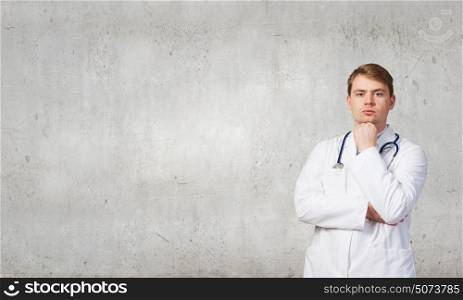 Portrait of confident doctor with arm on chin. Male positive doctor
