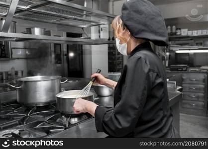 Portrait of confident female chef working in commercial kitchen. High quality photo. Portrait of confident female chef working in commercial kitchen.