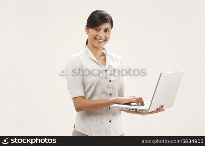 Portrait of confident female executive using laptop