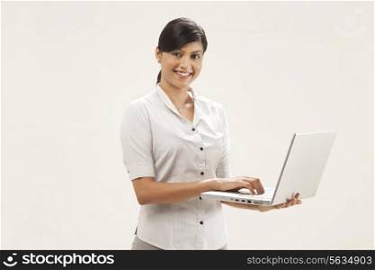 Portrait of confident female executive using laptop