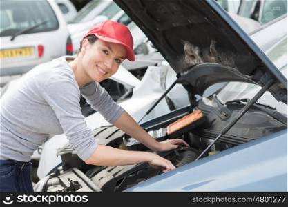 portrait of confident female mechanic fixing car