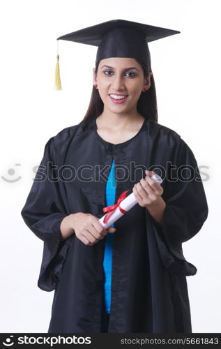 Portrait of confident graduate student holding diploma against white background