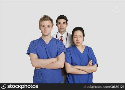 Portrait of confident healthcare workers standing over gray background