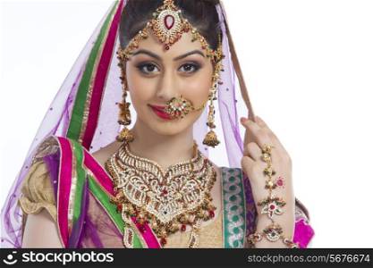 Portrait of confident Indian bride over white background