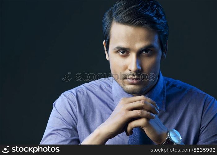 Portrait of confident Indian businessman isolated over black background