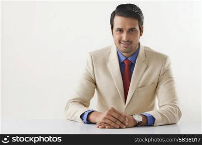 Portrait of confident Indian businessman sitting at office desk