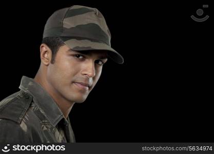 Portrait of confident Indian soldier over black background