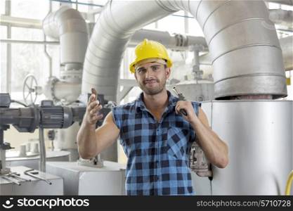 Portrait of confident industrial worker holding wrench