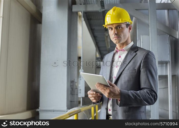 Portrait of confident male architect holding digital tablet in industry