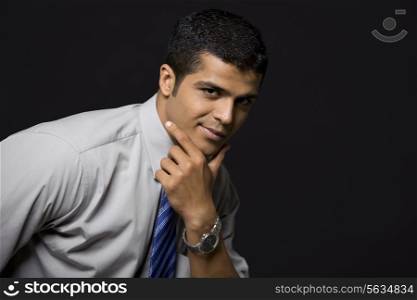 Portrait of confident male executive over black background
