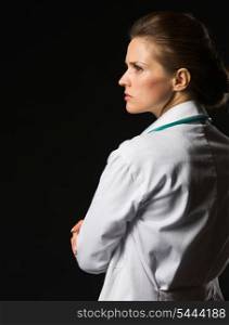 Portrait of confident medical doctor woman looking on copy space isolated on black