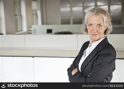 Portrait of confident senior businesswoman with arms crossed in office