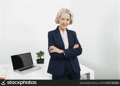 Portrait of confident senior businesswoman with arms crossed in office