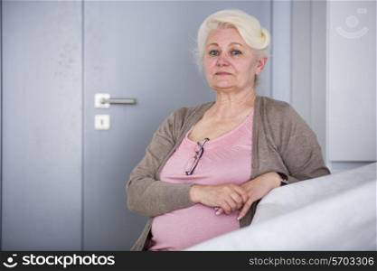 Portrait of confident senior woman sitting in house