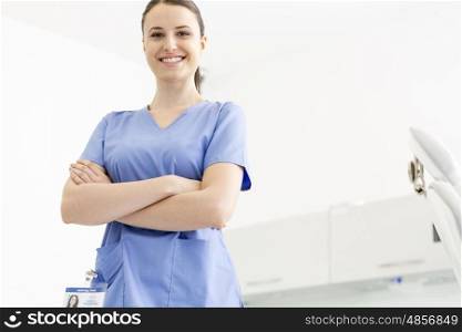 Portrait of confident smiling nurse with arms crossed at clinic