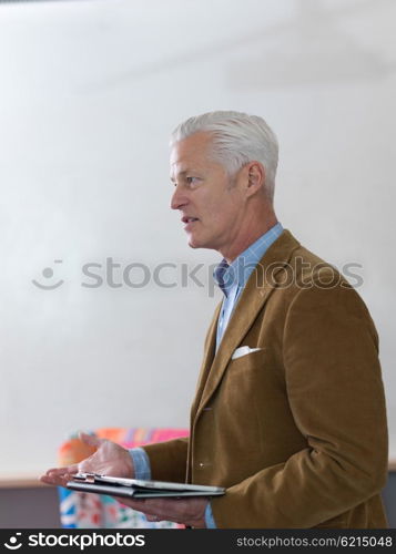 portrait of confident teacher solving problems on whiteboard in classroom