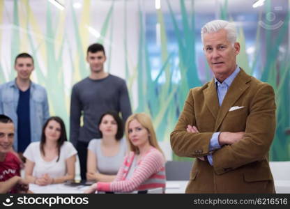 portrait of confident teacher, students group in background