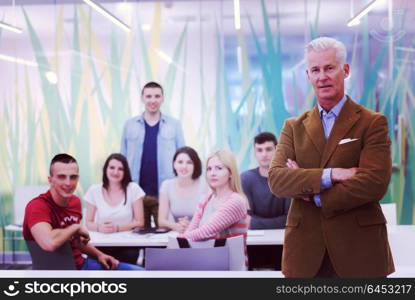 portrait of confident teacher, students group in background