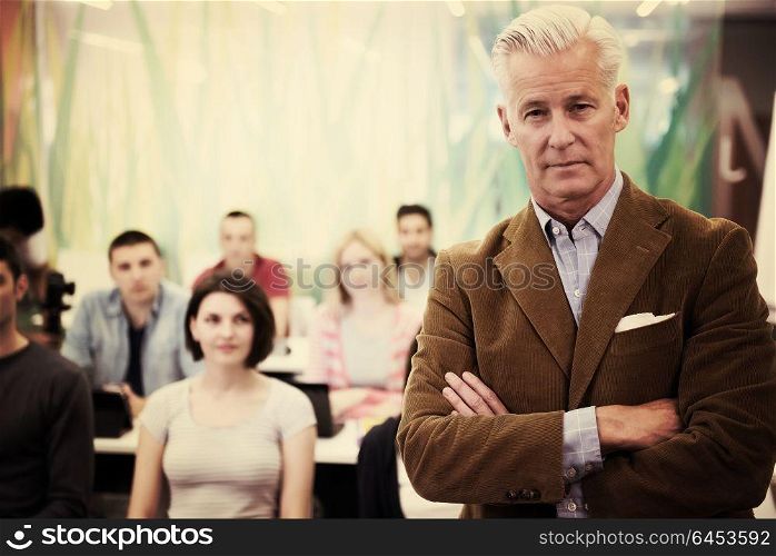 portrait of confident teacher, students group in background