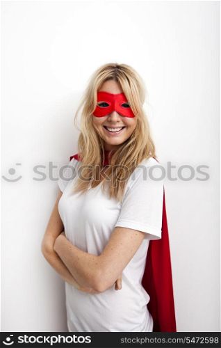 Portrait of confident woman in superhero costume against white background