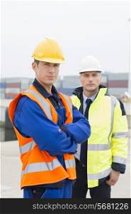 Portrait of confident worker standing with coworker in shipping yard