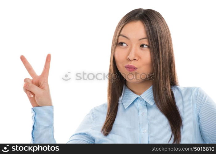 Portrait of confident young business woman showing victory gesture on white background