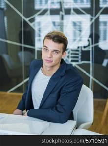 Portrait of confident young businessman sitting at conference table