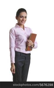 Portrait of confident young businesswoman holding diary over white background