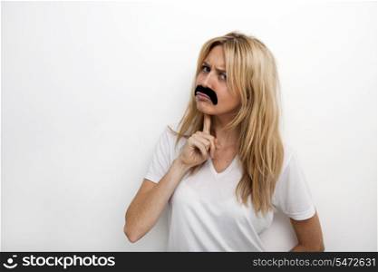 Portrait of confused in fake mustache against white background