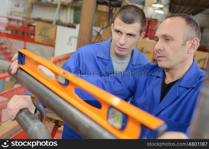 portrait of construction worker checking level of a metal piece