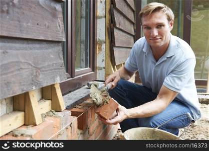 Portrait Of Construction Worker Laying Bricks