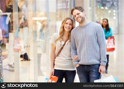 Portrait Of Couple Carrying Bags In Shopping Mall
