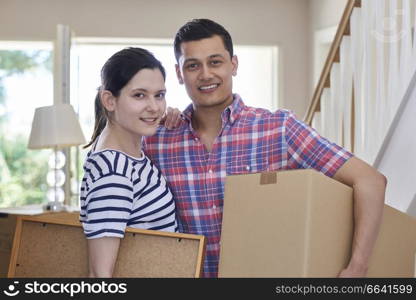 Portrait Of Couple Carrying Boxes Into New Home On Moving Day