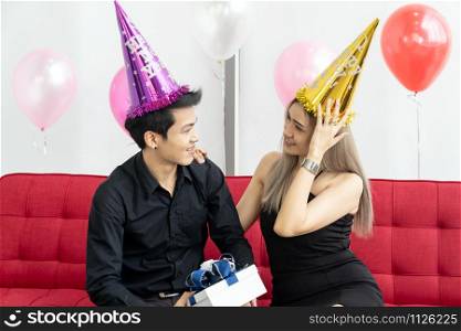Portrait of couple holding gift box present celebraing New Year Party festival holiday in living room