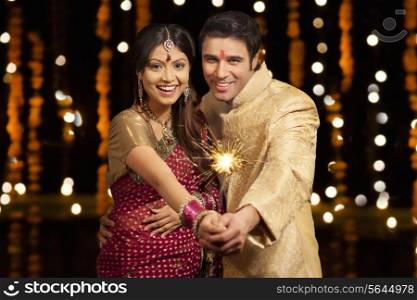 Portrait of couple holding sparkler