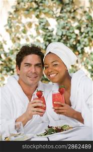 Portrait of couple in bathrobes, drinking at health spa