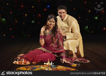 Portrait of couple in front of rangoli
