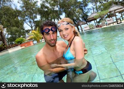 Portrait of couple in pool with goggles