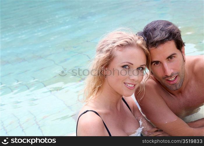 Portrait of couple in resort swimming pool