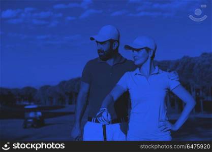 portrait of couple on golf course. portrait of happy young couple on golf course duo tone