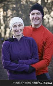 Portrait Of Couple On Winter Run Through Woodland
