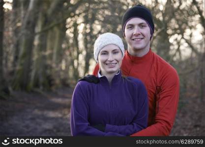 Portrait Of Couple On Winter Run Through Woodland