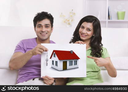 Portrait of couple pointing to picture of car