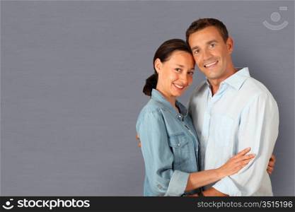 Portrait of couple standing on grey background