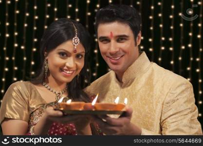 Portrait of couple with tray of diyas