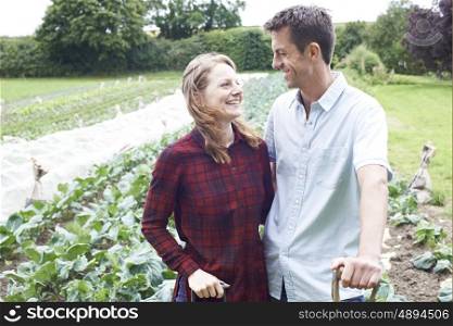 Portrait Of Couple Working In Organic Farm Field