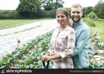 Portrait Of Couple Working In Organic Farm Field
