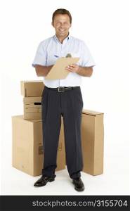 Portrait Of Courier Standing Next To Parcels, Holding A Clipboard