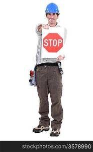 portrait of craftsman holding stop sign