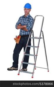 portrait of craftsman standing cross-armed near ladder